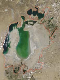 Спутниковая съемка Аральского моря, сделанная летом 2002 года.<br />Красным пунктиром показана площадь озера по состоянию на 1960 год.